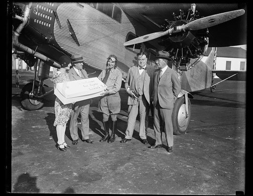 Group next to airplane with package addressed to "Dr. Hugo Eckener, Graf-Zeppelin, Lakehurst, N.J.