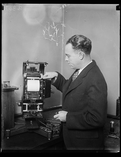 Colored radio recorder is latest in radio receivers. E.B. Judson of the Bureau of Standards and his two colored radio recorder, automatically recording signals in two colors, red and black. This automatic receiver is capable of receiving signals from American or European stations