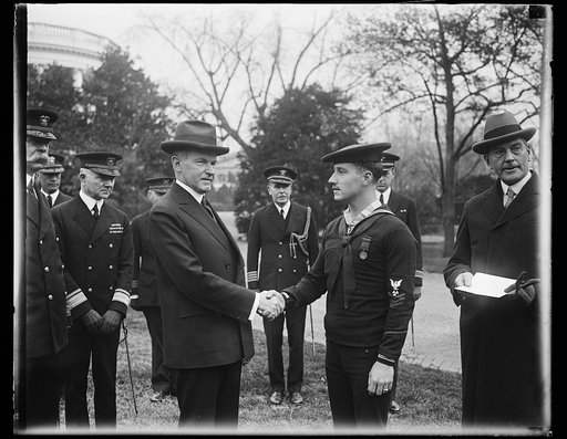 President Coolidge congratulates sailor after presenting him with Congressional Medal of Honor. President Coolidge congratulating William R. Huber, Machinist Mate, First Class, United States Navy, after presenting the sailor with the Congressional Medal of Honor at the White House today Huber was aw