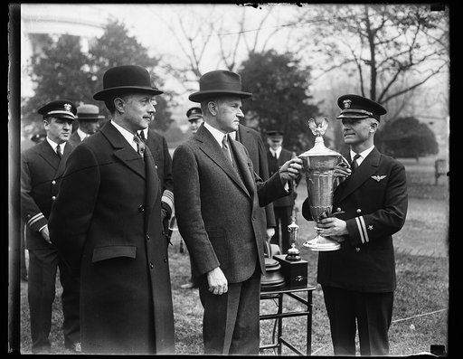 President Coolidge presents Herbert Schiff trophy to crack Navy Flyer. For performing the feat of keeping his plane in the air for 1251 hours without an accident of any kind during the last year Lieut. James E. Dyer, crack U.S. Navy flyer, was presented with the Herbert Schiff Trophy by President Co