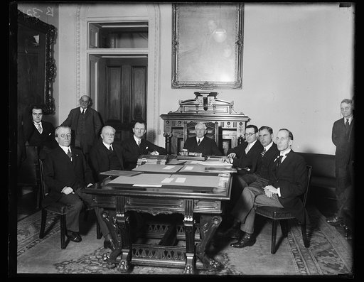 Group at table; Frank Kellogg at head of table