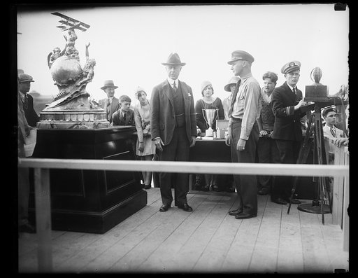 Naval aviator sets new speed mark to win Curtiss Marine Trophy., Lt. W.G. Tomlinson, right, roaring over a 100 mile course on the Potomac River, in his tiny Navy fighting plane, won the Curtiss Marine Trophy race today and broke the record for service seaplanes by a wide margin. His record speed of 