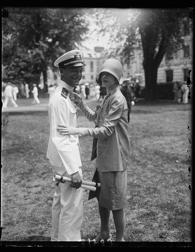 Washington girl pins epaulettes on sweetheart graduate at U.S. Naval Academy., A.C. Walker of Asheville, North Carolina, member of the graduating class of Annapolis today, has the epaulettes of ensign in the United States Navy