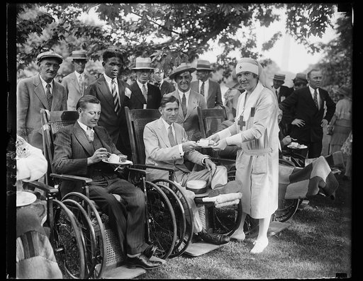 Wife of Secretary of Labor assistant in serving disabled war veterans at White House. Mrs. James J. Davis, wife of the Secretary of Labor, serving refreshments to Earl Swayles, a disabled veteran, at the garden party given at the White House today for the disabled war veterans. Swayle's home is in P