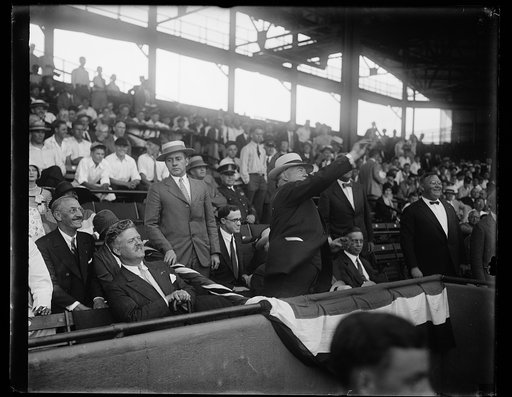 Herbert Hoover throwing baseball from stands at stadium