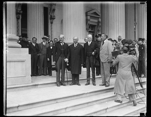 Greeted by the Vice President. Premier Ramsey MacDonald, today made his first call upon the Vice President of the United States. The group, made on the steps of the United States Capitol shown, left to right: Premier MacDonald, Vice President Curtis, Ambassador Howard and Senator Stephen G. Porter o