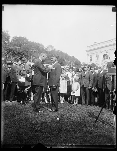 President Hoover presents Congressional Medal of Honor to World War hero. Michael Valente, formerly Private, Company D, 107th infantry, 27th Division during the World War, receiving from President Hoover the Congressional Medal of Honor at the White House today. Valente receives the medal for braver