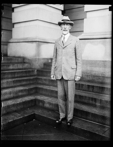 In spotlight at Navy probe hearing at U.S. Capitol. Rear Admiral J.M. Reeves, of the General Board of the United States Navy, snapped as he left the Capitol today after appearing before the Senate Committee investigating the lobbying at the Geneva Conference. Admiral Reeves answered to the charge th