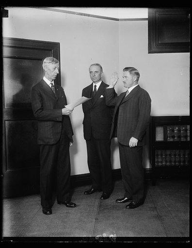 Succeeds Miss Willebrandt. G.A. Youngquist, of St. Paul, Minnesota, was sworn in today as Assistant Attorney General of the United States to suceed Miss Mabel Walker Willebrandt. In the photograph, left to right: Charles Assistant Chief Clerk of the Department of Justice, who administered the oath; 