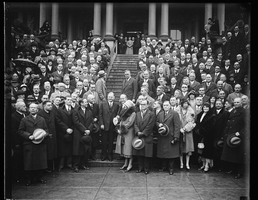 Educators meet Hoover. Members attending the 16th Annual meeting of the Association of American Colleges meet President Hoover and pose for this photograph on the steps of the temporary executive offices, the State, War and Navy building. In the center of the group, left to right: Robert L.Kelly, pe