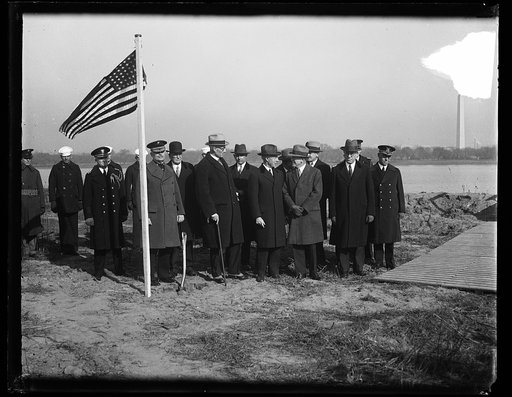 Group gathered near river; Washington Monument in background