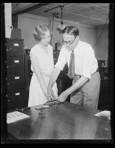 U.S. Worker finger printed. Starting in July, all civil service employees of the United States government will have their finger prints recorded for purpose of identification. Miss Opal Boyce, employee of the civil service department, is shown having her fingerprints made by John H. Clark, assistant