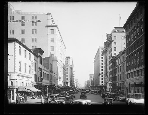 Street view looking east down F Street, N.W., from 15th Street, with Old Ebbitt Cafeteria and Grill, 1427 F Street, at far left, and Garfinckel's Department Store. Washington, D.C.