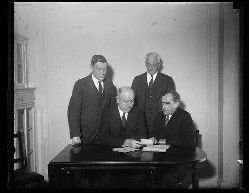 James A. Farley at desk, with group