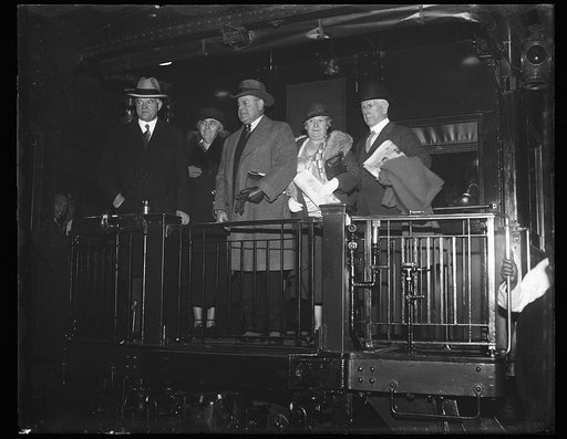 Herbert Hoover and Lou Hoover with group on back of train