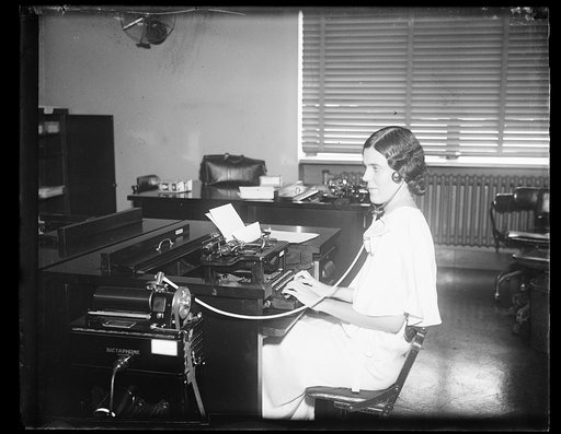 Woman working at typewriter in office