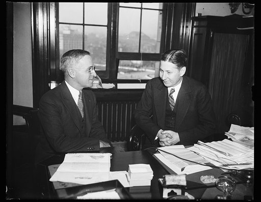Senator Harry S. Truman (left) with man at a desk