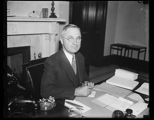 President Harry S. Truman seated at desk