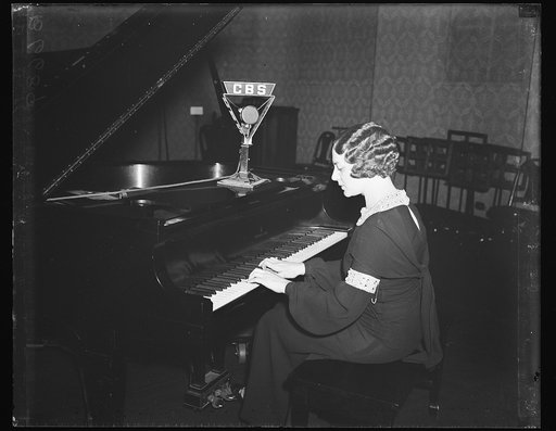 Woman playing piano with CBS microphone