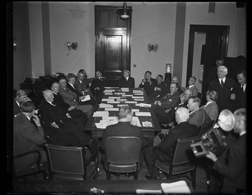 Group at table; includes Carter Glass at left; J. Hamilton Lewis? at back right corner of table