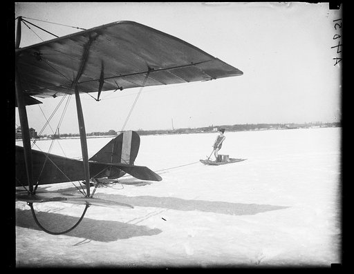 Sled being pulled by airplane in snow