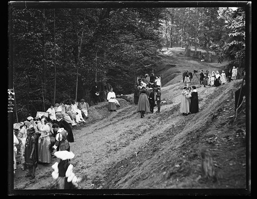 People in costumes in forest and group with motion picture camera