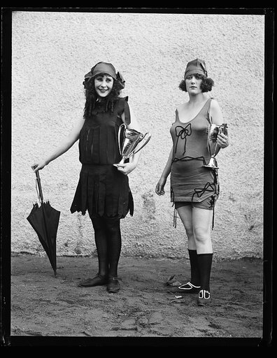 Women in bathing suit with prize cups