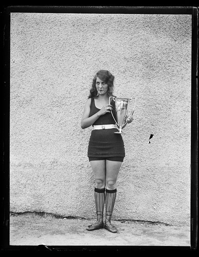 Woman in bathing suit with trophy cup