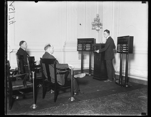 Representative [...] (left) and R.N. Ellio[...] of Ind. demonstrating [...] voting machine invented [...] of each member of the [...] electronically [...] controlled [...