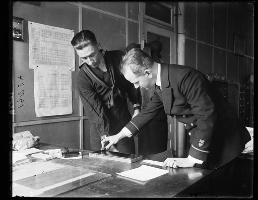 Pay clerk John A. Shaw (right) is shown in the picture taking the fingerprints of Arthur G. Whaley, at Coast Guard headquarters, Wash., D.C.