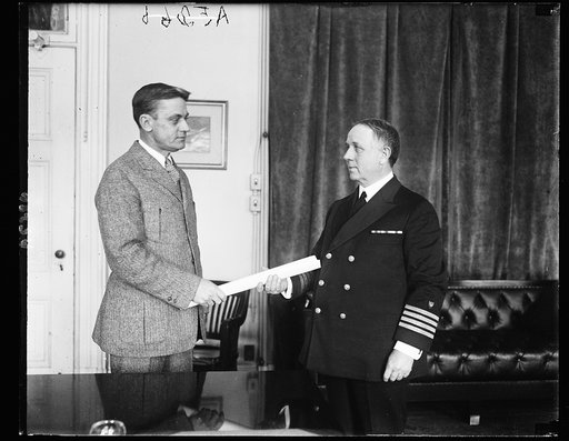 Capt. Wm. E. Reynolds (right) receiving his commission as a Rear Admiral in the U.S. Coast Guard from Asst. Secy. Clifford of the Treasury. Adml. Reynolds, who is Commandant of the Coast Guard, is the first officer to hold his rank. Has served with Coast Guard since 1878. Native of Md.