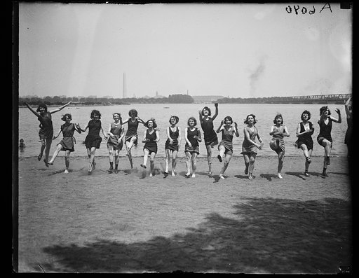 Bathing beauties dancing on beach. Washington Monument in background
