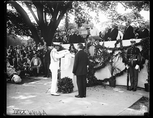 John W. Weeks) at podium with Warren Harding, and others