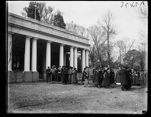 Delegates attending the national conference of the Women's Party leaving the east entrance of the White House after meeing with President Coolidge and Mrs. Grace Anna Coolidge