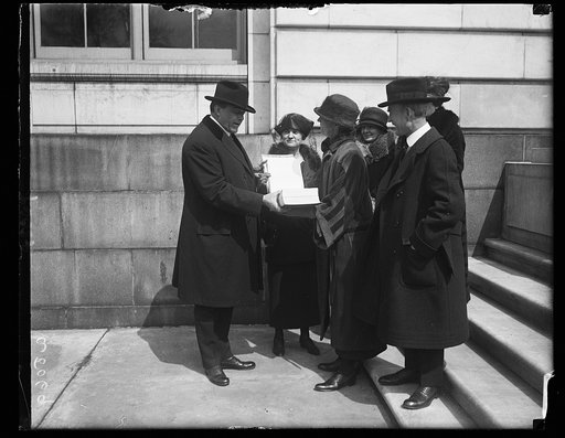 Miss Julienne Sessions, Pres. of the Ohio League of Women Voters, presenting a World Court petition to Sen. F.B. Willis, Chmn. of the Senate Foreign Committee. Left to right: Sen. Willis, Miss Sessions, and Sen. Simon D. Fess of Ohio