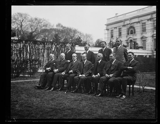Coolidge Cabinet outside White House. Front row, left to right: Henry Stewart New, John W. Weeks, Charles Evans Hughes, Calvin Coolidge, Andrew Mellon, Harlan F. Stone, and Curtis D. Wilbur. Back row, left to right: James J. Davis, Henry C. Wallace, Herbert Hoover, and Hubert Work