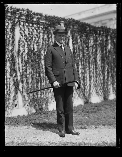 Pres. Coolidge snapped on one of his daily walks sporting a "big stick," the gift of A. J. Shell of Wise County, Va.