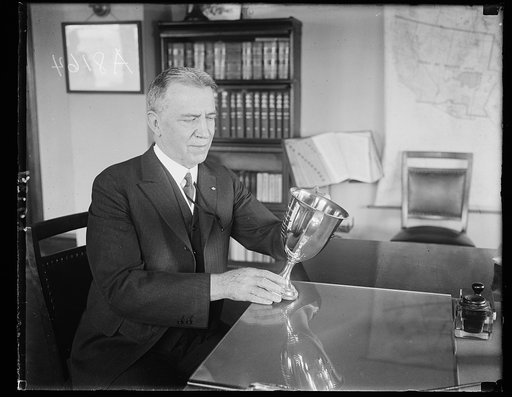 D.B. Carson, who supervises licensing and operation of all radio stations in U.S., shown holding the Herbert Hoover Cup of best all-around amateur radio station in U.S. which was awarded to Donald C. Wallace, Minneapolis, Minn. His station is 9-ZT--9-XAX