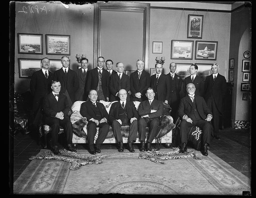 Officials and members of Dip. Corps guests at luncheon given by Dr. L.S. Row, Dir. Gen. of Pan-Amer. Union, in honor of Peruvian Ambassador Dr. Herman Velarde. Front row, left to rt.: Secy. Wallace, Amb. Velarde, Secy. Hughes, Secy. Wilbur, Dr. Jose F. Cavero. Back row: Dr. L.S. Rowe, Admiral Leigh 