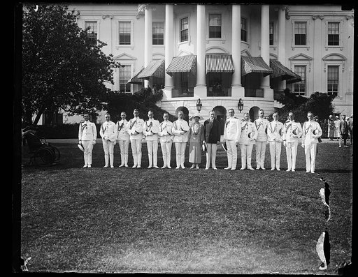 Pres. and Mrs. Coolidge with the W.H.[i.e., White House] military and naval aides, posed on the W.H. lawn just before the garden party to the wounded veterans. At Mrs. C's right: Col. C.O. Sherrill and at the Pres.'s left, Capt. Adolphus Andrews