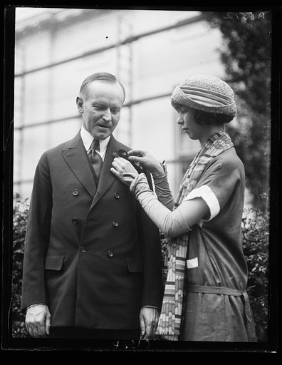 Grace Newton, daughter of Cong. Walter H. Newton of Minn., pinning flower on Coolidge