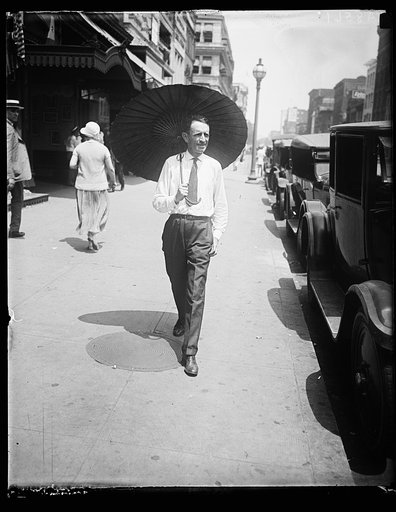 With Wash. melting under the hottest day of the year, Russell T. Edwards of the Amer. Tree Assn. starts a new style for men by throwing his hat away and carrying a chinese parasol. He carries it on the golf course too