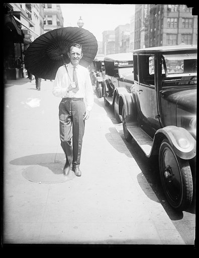 With Wash. melting under the hottest day of the year, Russell T. Edwards of the Amer. Tree Assn. starts a new style for men by throwing his hat away and carrying a chinese parasol. He carries it on the golf course too