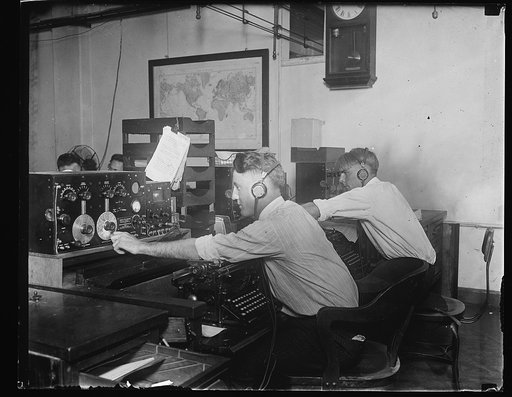Men at medium wave receiver and typewriters