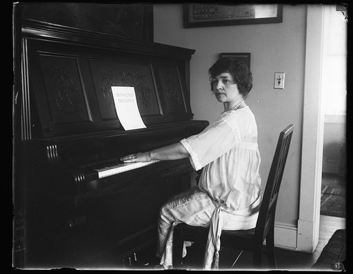 Woman at piano with music "I didn't raise my boy to be a slacker"