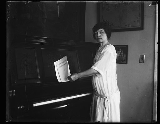 Woman at piano with music "I didn't raise my boy to be a slacker"