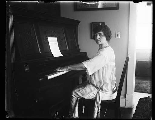 Woman at piano with music "I didn't raise my boy to be a slacker"