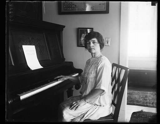 Woman at piano with music "I didn't raise my boy to be a slacker"