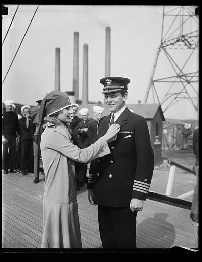 Woman with Red Cross pinning Naval Officer