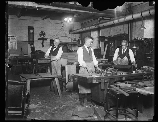 Where our congressmen's chairs are repaired. The cabinetmakers room in the United States Capit[...] the chairs of Senators and Represenatives are repaired [...] other articles are made for use throughout Capitol Hill [...] cabinet makers in the picture are, (left to right) Paul [...] W.L. Walling an
